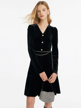 a lady in black v-neck velvet mini  dress with chain belt